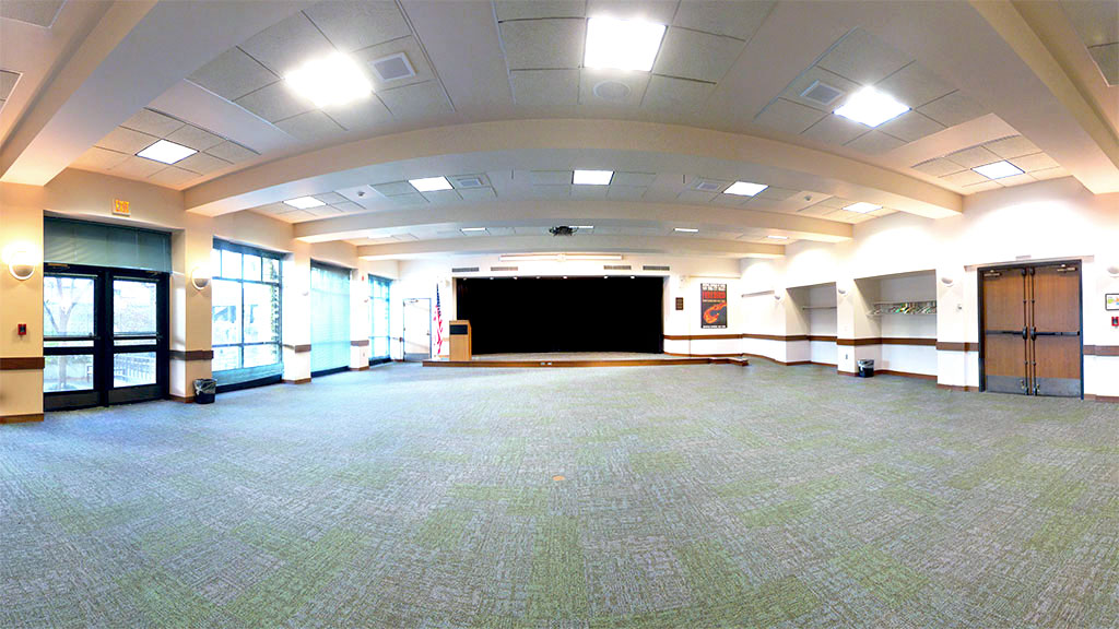 A wide view of nearly the full physical space of the room with the platform stage as the focus.