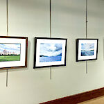 Thumbnail: Brilliantly colored, scenic photographs adorn a wall.