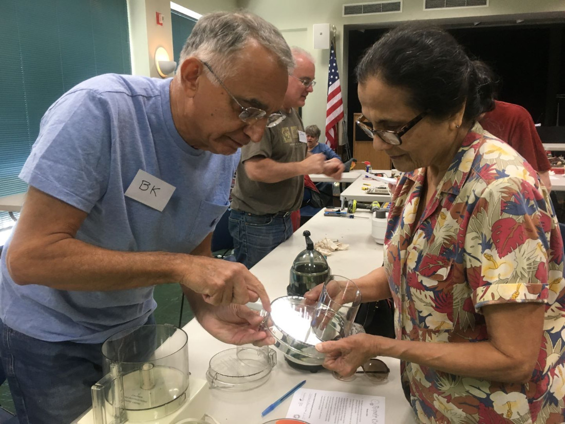 two people working on fixing a food processor at a Repair Cafe